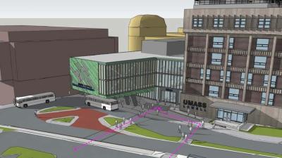 Rendering of five story building with smaller three story glass wing to the left of the five story building.  Umass Lowell in raised letter signage on the left of the larger building
